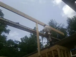 Carpenter setting a ridge beam over a new addition frame — Ice Dam Removal by Roofing Brothers in Dunkirk
